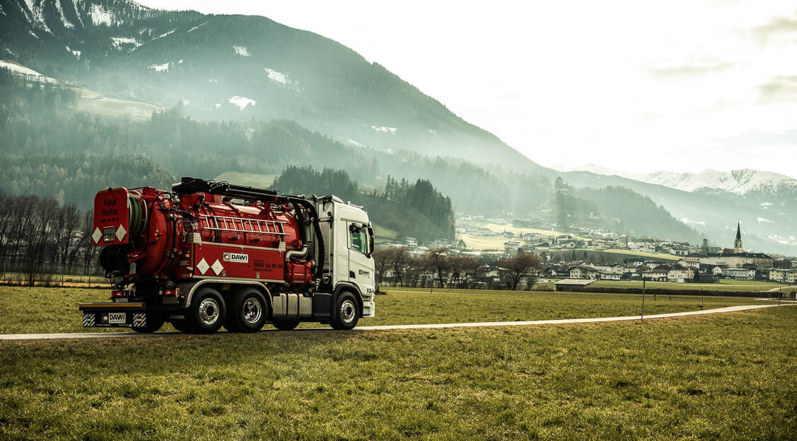 DAWI Spülfahrezug fährt auf der Straße in schöner Landschaft