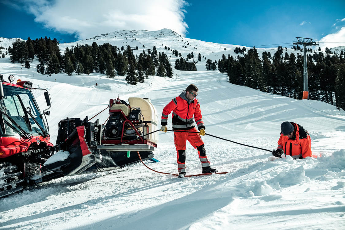 Zwei DAWI Mitarbeiter bei der Kanalreinigung auf einer Skipiste